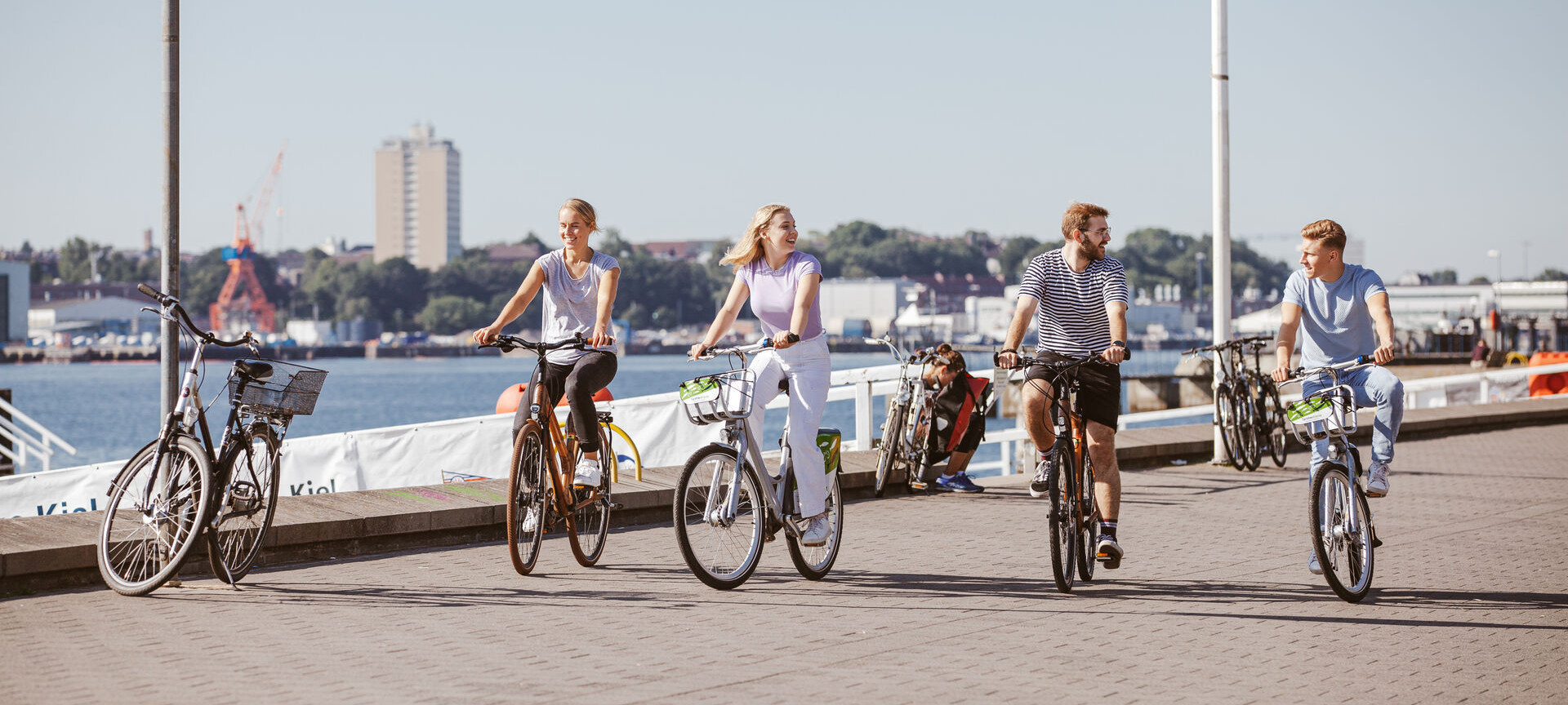 Vier Fahrradfahrer:innen fahren an der Kiellinie entlang