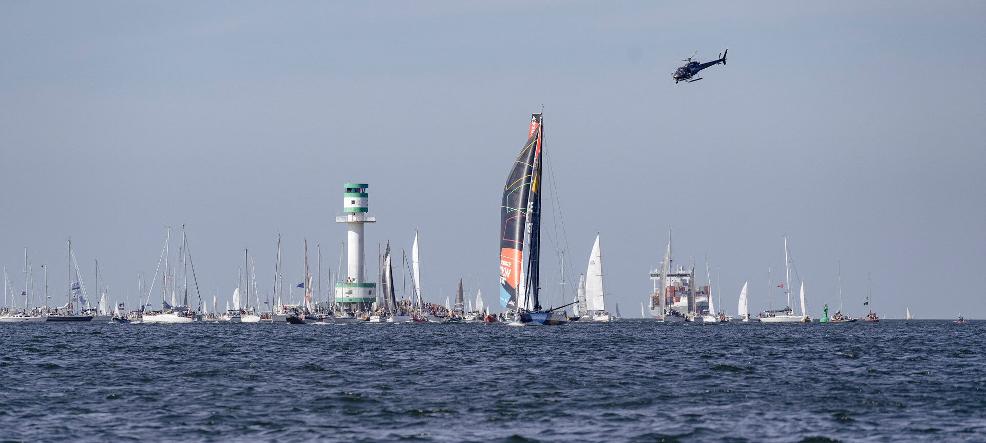 IMOCA von Malizia, mehrere Boote und Leuchtturm an der Kieler Förde