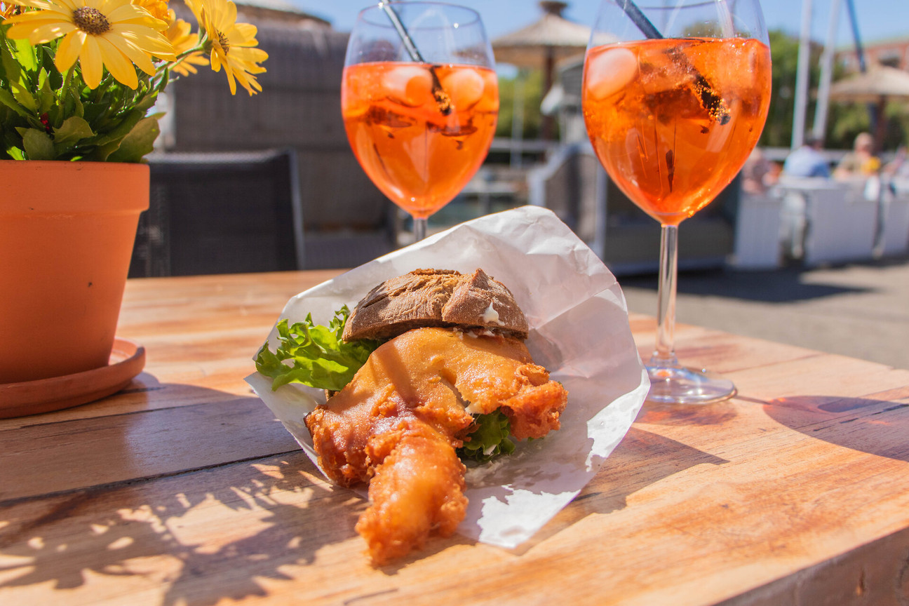 Ein Fischbrötchen und zwei Gläser Aperol