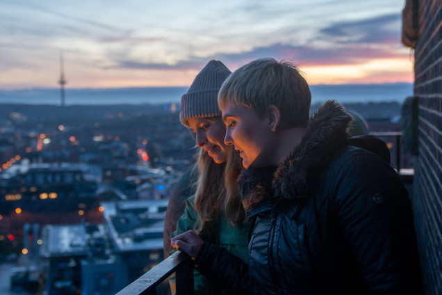 Zwei Personen auf dem Kieler Rathausturm mit Blick über die Dächer Kiels