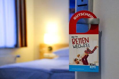 Gutschein für Bettenwechsel hängt an einer Hoteltür