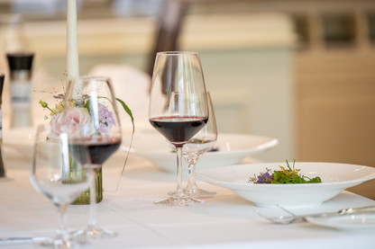 Gedeckter Tisch mit zwei gefüllten Weingläsern.