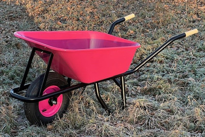 Pinke Schubkarre im Heu