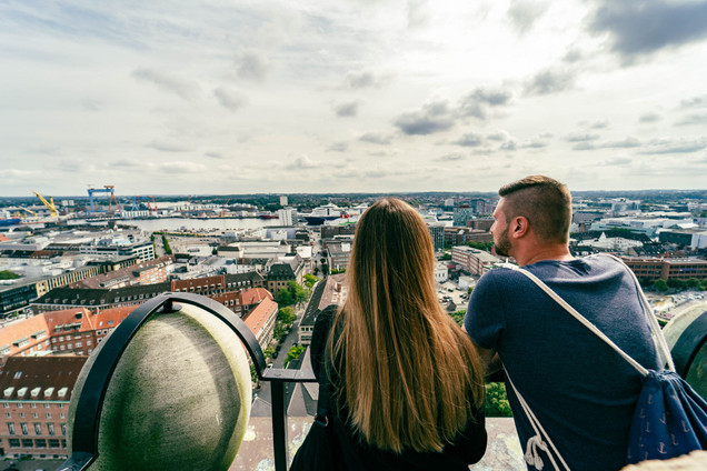 Paar schaut vom Rathausturm in Kiel runter auf die Stadt.