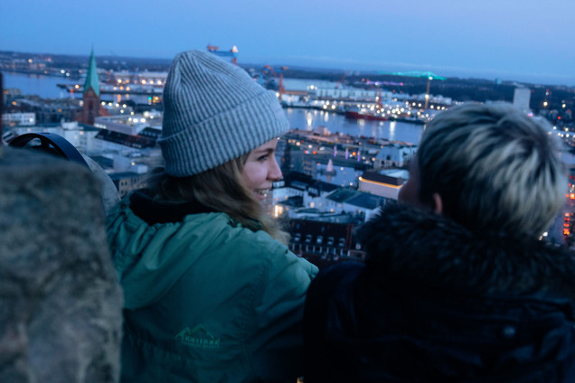 Zwei Personen auf dem Kieler Rathausturm mit Blick über die Dächer Kiels