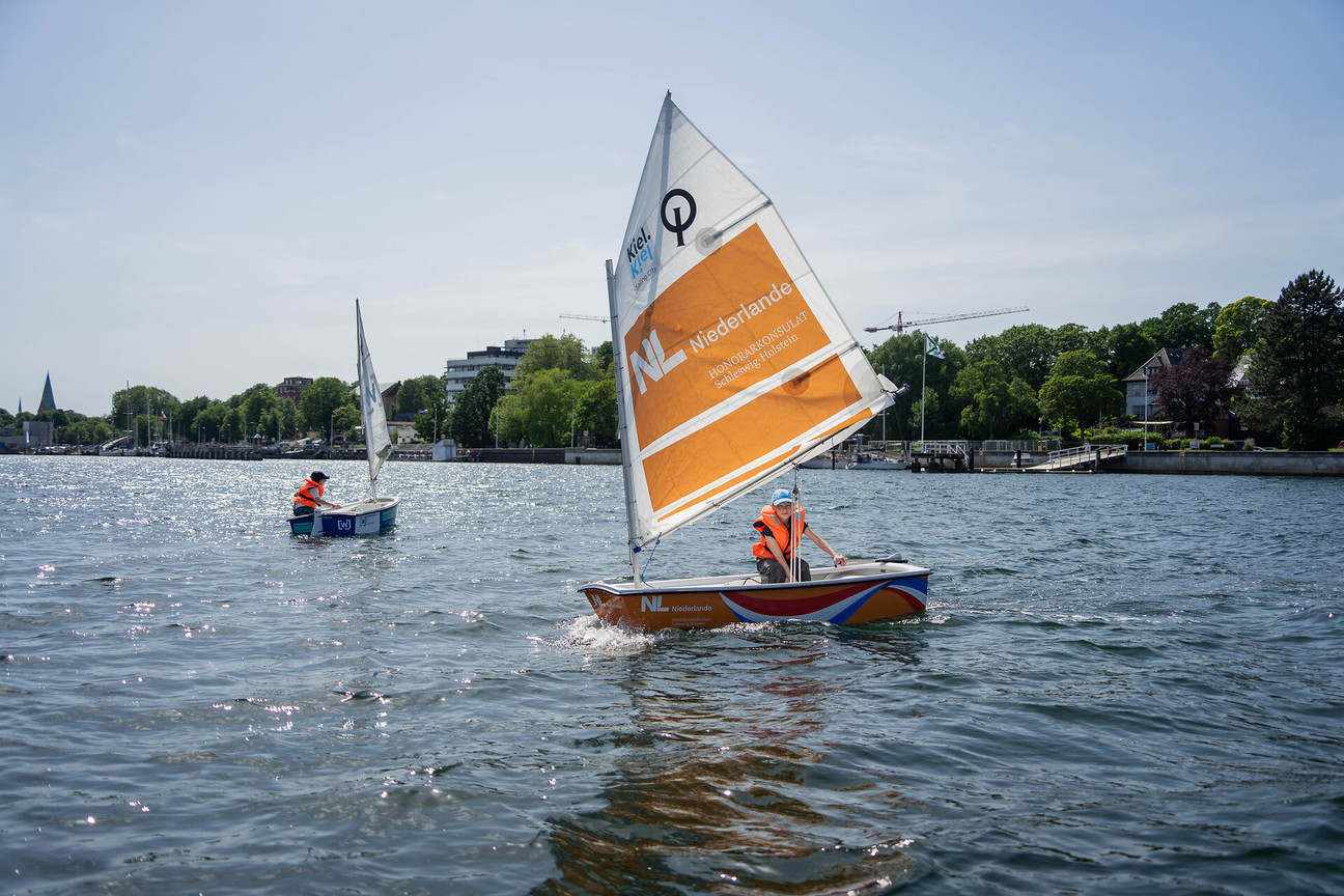 Zwei Kinder segeln in Optis auf der Kieler Förde 