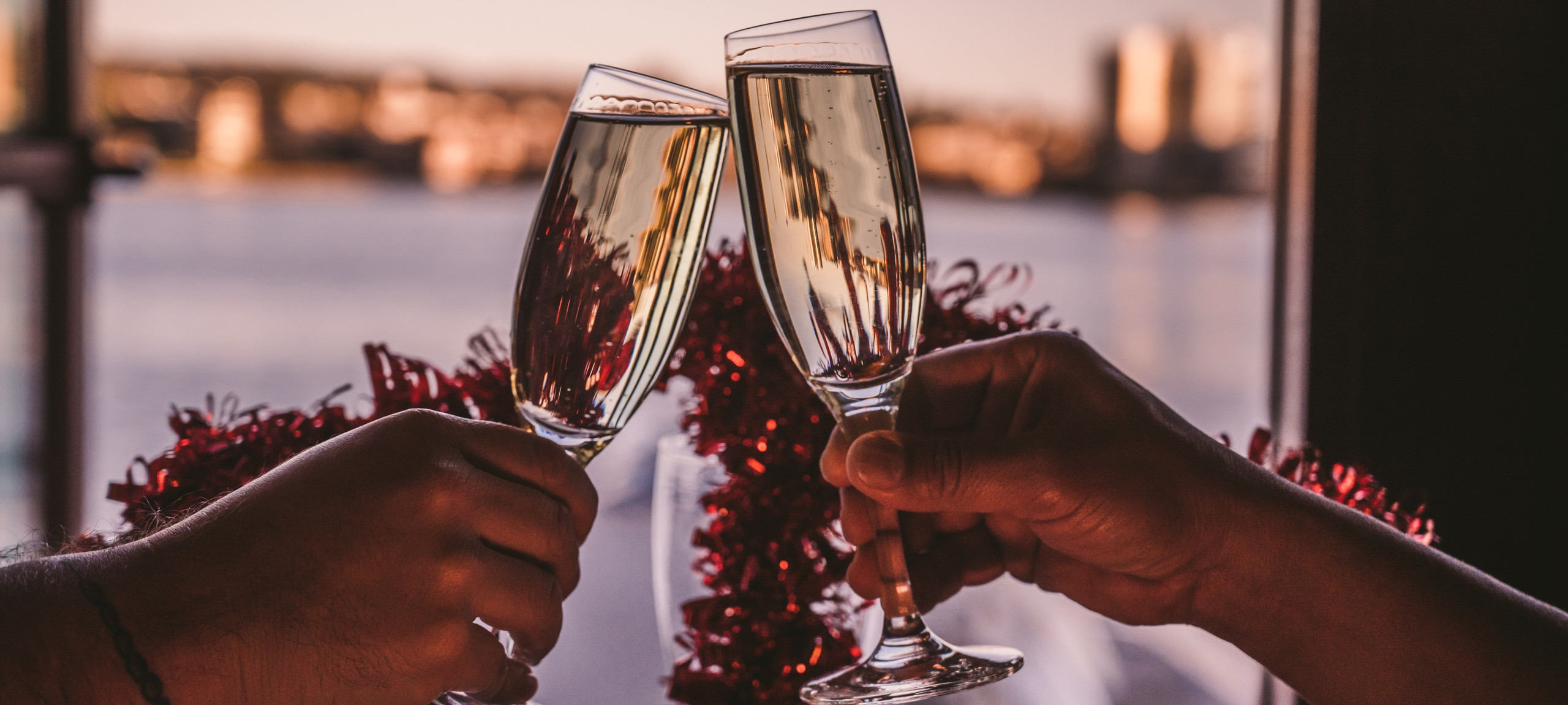 Zwei Hände stoßen mit Sektgläsern an