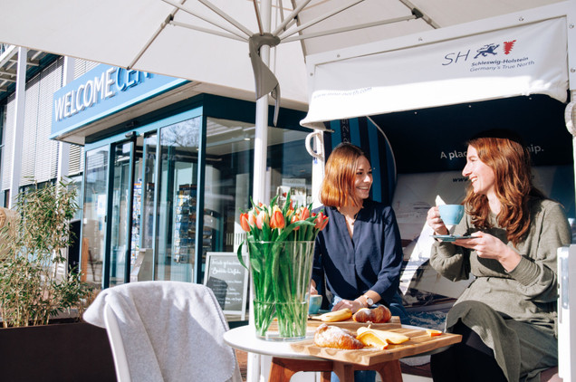 Zwei Frauen essen und trinken im Welcome Café