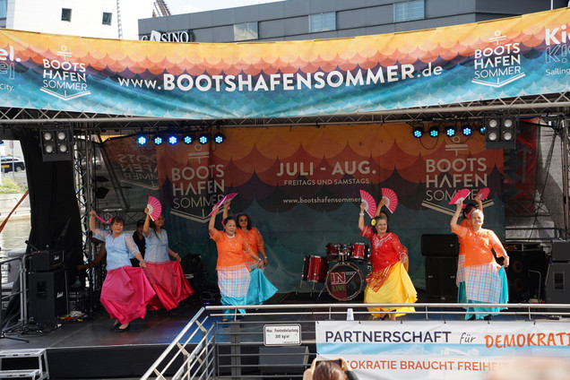 Gruppe von acht Frauen tanzen mit ihren Trachten und Fächern auf der Bühne vom Bootshafensommer