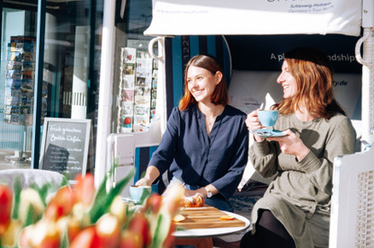 Zwei Frauen sitzen in Strandkorb und frühstücken