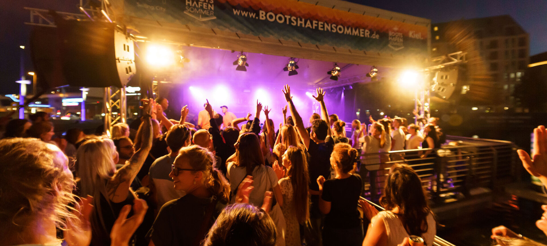 Begeisterter Publikum vor der Bühne am Abend beim Bootshafensommer