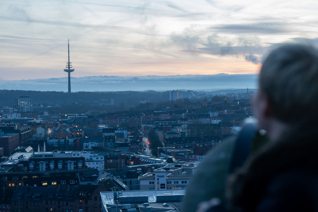 Mann und Frau genießen den Ausblick über Kiel vom Rathausturm aus