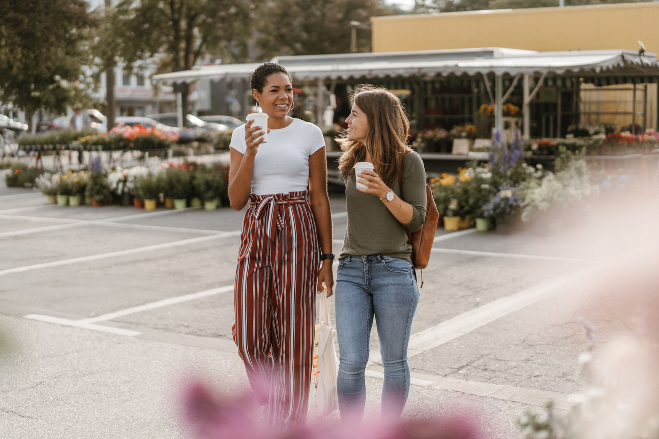 Zwei Frauen spazieren über den Wochenmarkt am Exer