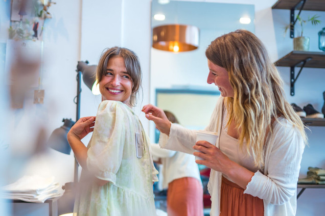 Zwei Frauen probieren Kleidung im Laden an