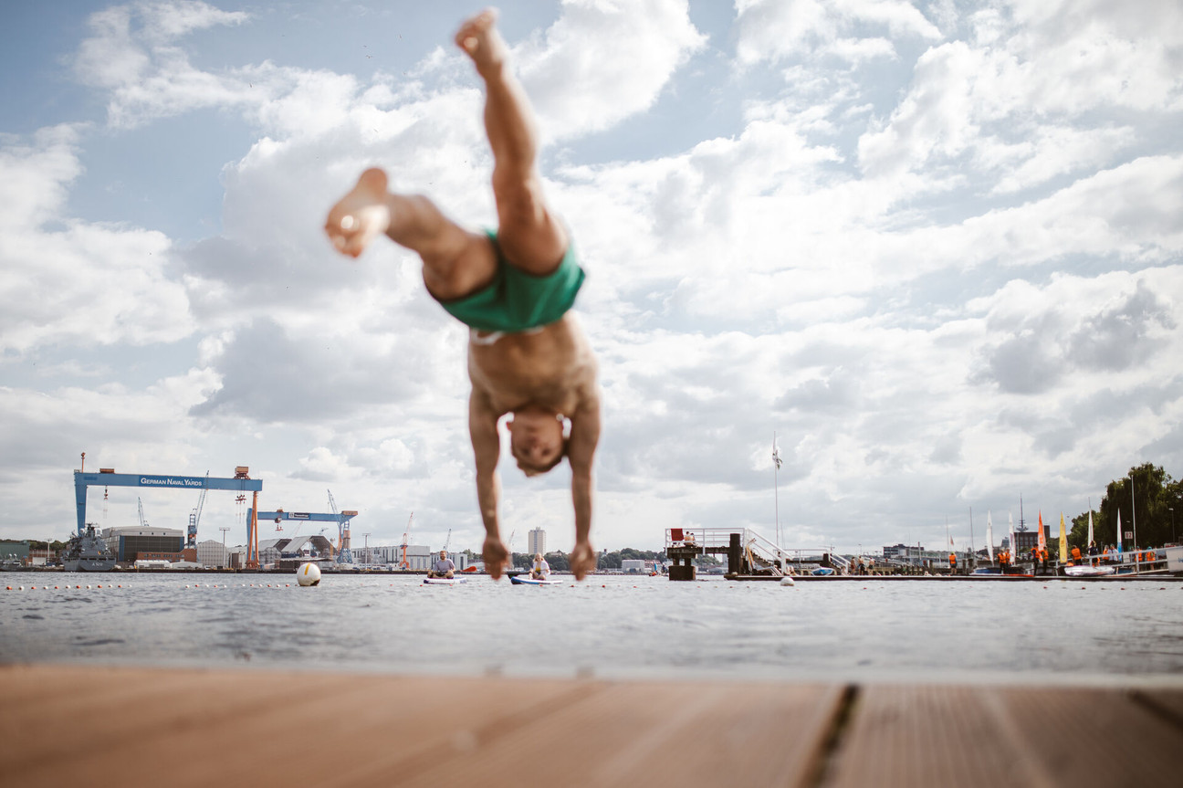 Mann springt vom Badesteg in die Kieler Förde