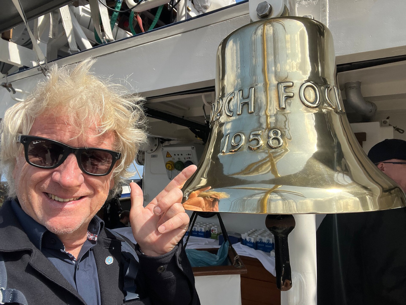 Uwe Wanger neben Schiffsglocke auf der Gorch Fock