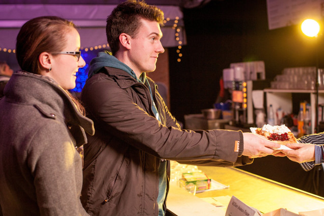 Pärchen kauft Waffeln mit heißen Kirschen und Sahne beim Stadtwerke Eisfestival