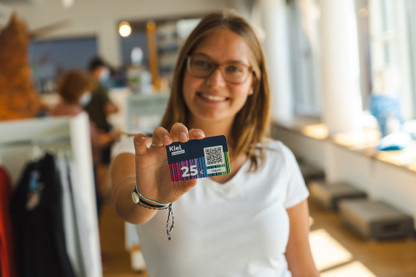 Eine Person hält einen KielGutschein in die Kamera