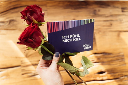 Kielgutschein und zwei Rosen als Valentinstagsgeschenk