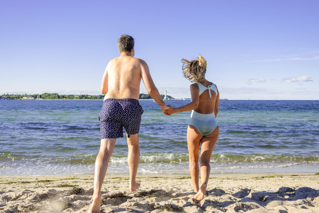 Paar läuft Hand in Hand ins Meer
