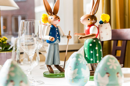 Zwei Osterhasen auf einem gedeckten Frühstückstisch
